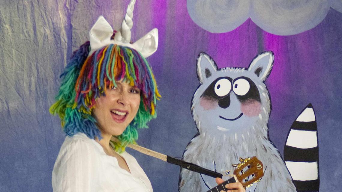 Ein Einhorn mit bunter Mähne spielt Gitarre.