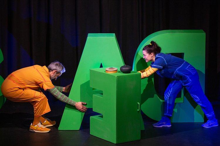 Zwei Kinder spielen mit großen Bauklötzen in Form von Buchstaben.