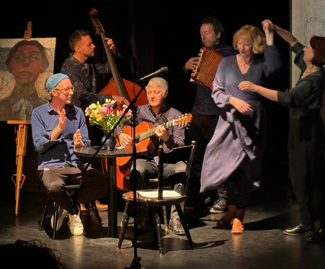 Eine Band spielt und zwei Frauen tanzen dazu - links steht ein Selbstporträt der Malerin Paula Modersohn-Becker