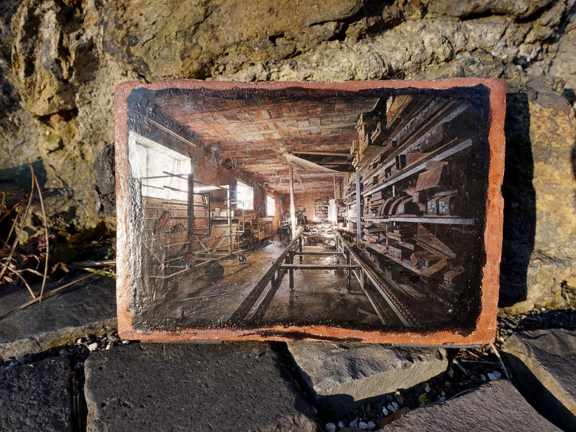 Das Foto einer alten Werkstatt, auf einen Ziegelstein gedruckt.